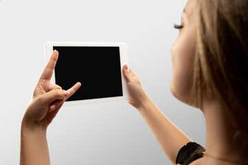 Rock horn gesture. Close up female hands holding tablet with blank screen during online watching of popular sport matches, championships. Copyspace for ad. Devices, gadgets, technologies concept.