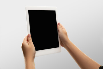 Attented.Close up female hands holding tablet with blank screen during online watching of popular sport matches, championships. Copyspace for advertising. Devices, gadgets, technologies concept.
