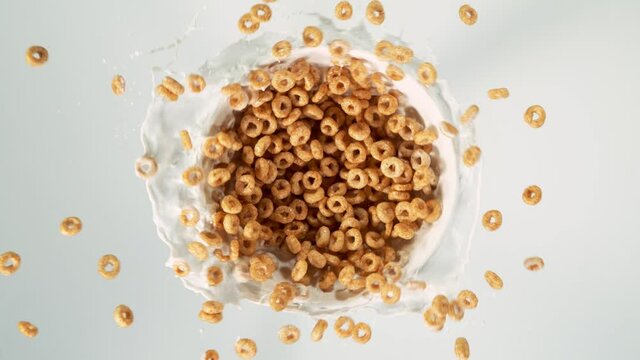 Super slow motion of rotating cereal pieces with milk splashes on white. Filmed on high speed cinema camera, 1000fps.