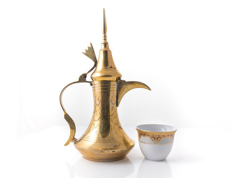Traditional arabic coffee mug called Dallah and coffee cup on white background - stock image