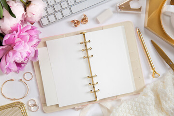 Women's diary and golden stationery. Bouquet of pink peonies. Glasses, a white keyboard, pen,...