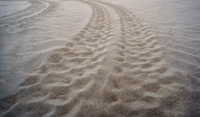 Wheel track trace of vehicles on the sand as background.