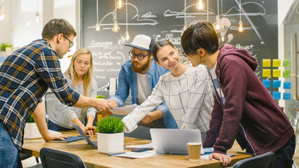 Diverse Team of Talented Young Developers have Brainstorming Session. They Have Discussion, Use Laptop and Consult Documents. Stylish People Work in the Modern Environment.