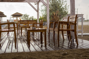 A sudden downpour at the beach bar, everyone left because the weather was very bad. Tourism, bad weather.