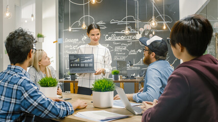 Beautiful Woman Spokesperson  Shows Laptop with Infographics Display Great Results to a Diverse Group of Talented Young Creative People, They Have Discussion at the Meeting Table.