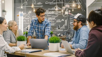 Creative Project Manager Talks to Talented Young Developers at the Team Meeting, They Discuss, Aims, Goals and New Year Plans. Stylish Business Office. 