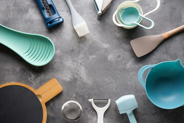 Various kitchen utensils on a gray table background, top view, with place for text.