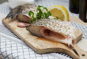 
Fish on the table, and next to it is parsley and a lemon