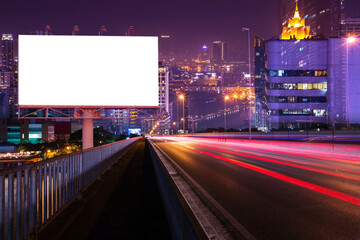 Blank billboard on light trails, street and city in the night - can advertisement for display or montage product or business.