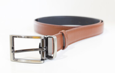 Brown leather belt isolated on white. Rolled male belt