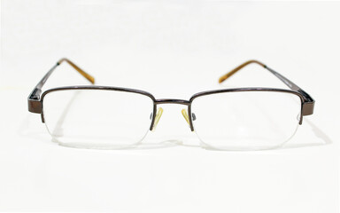 Transparent metallic glasses on bright background. Close up of used reading eyeglasses