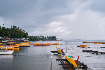 Traditional fishing boats harbour at rainy day. Siargao, Philippines.