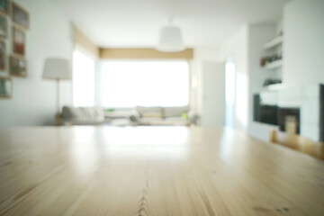 Very bright abstract living room design. Only the texture of the table in the front is in focus. The abundance of light turns the house into a lovely and cozy home. White walls with nice wood details.