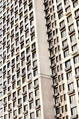 Fototapeta premium Modern residential skyscrapers facade close-up. Commercial real estate. Modern apartment buildings design. Many windows in the wall of a modern house. Residential city tower.