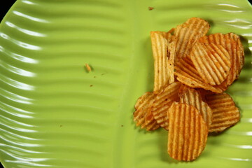 savory snacks with a spicy, salty and sweet orange color on a leaf-shaped green plate