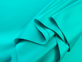 Beautiful elegant wavy turquoise silk or satin luxury cloth fabric texture, abstract background...