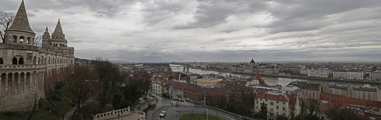 Fototapeta na wymiar A panoramic view over the lovely city of Budapest, Hungary. The Buda Castle is looking over the Danube river, to the Pest side of the capital. The ominous, rainy clouds give a romantic, medieval feel.
