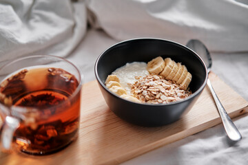 Good morning. Breakfast in bed. Bowl of granola and cup of hot tea.