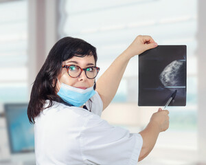 A physician specializing in women’s health shows an x-ray image of female breast