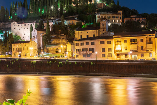 Night photo along the Adige river overlooking the Roman theater and San Pietro castle, city of Verona, Italy.