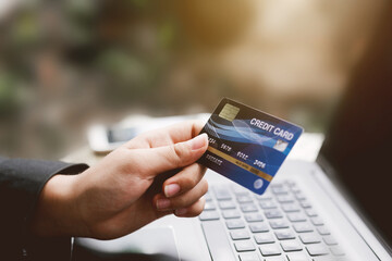 Hands holding credit card and using laptop. Online shopping and small business concept.