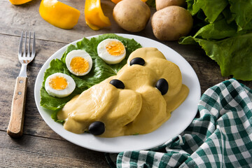 Traditional Peruvian papa a la huancaina on wooden table	