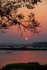 Fototapeta na wymiar A colorful dawn over the river Narmada with sunrise at Cheepaner Ghat, Madhya Pradesh, India.