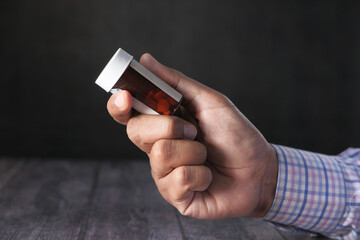 Close up of man hand holding pill container 
