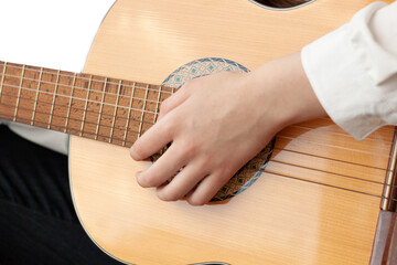 Close up of a girl's hand on the strings of a guitar