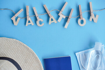 Top view hat,mask, sanitizer, passport on blue. Relax on coronavirus. Summer flatley, composition...