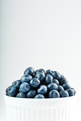 Juicy Blueberries in a white Cup on a white background.