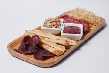 set of beer snacks with salami, peanuts, cheddar cheese and ketchup
