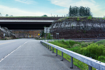 Empty road in ghost town Parksville, NY along walls of rocks. Exit toward highway 17