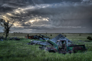 Fototapeta premium Old, abandoned vehicles on the Great Plains as Severe Weather Approaches