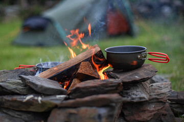 Pots and Pans cooking atop a wood burning camp fire in the English Countryside / wilderness