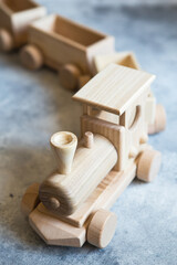 Fototapeta na wymiar Children's wooden toys. Children wooden train with wagons. Natural wood construction set. Educational equipment. Children's wooden locomotive with various cargo
