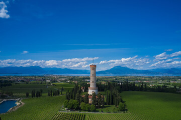Obraz premium Tower of San Martino della Battaglia Italy. Cumulus clouds in the background of blue sky, Lake Garda. Vineyard plantation at high altitude