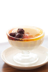 Close-up a cup of pudding with apple syrup and berries