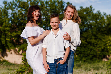 a cheerful family of three. mother and two teenage children in the sunshine