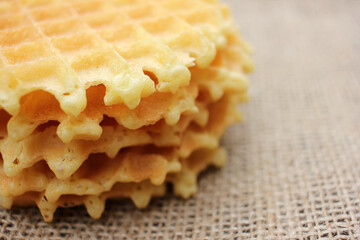 Close-up of Waffles on a burlap fabric texture background. Top view, copy space