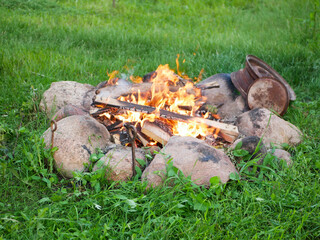 bonfire in stones on green grass