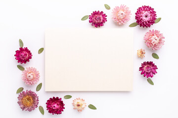 Flower composition. Blank of paper and frame made of dry flowers on white background. Flat lay. Top view. Copy space