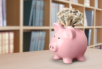 Piggy bank and paper money on desk