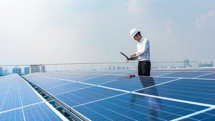 Electrical engineers are using laptops to monitor the operation of the solar rooftop. Renewable...