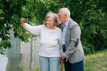 An elderly fashionable couple is photographed on a samrthon in the park.