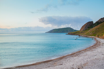 Sandy beach with mountains and blue sky