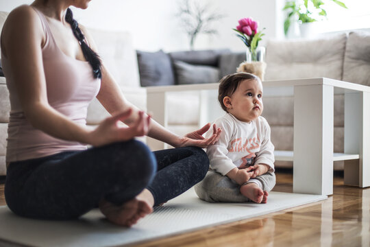 a woman teaches her child meditation