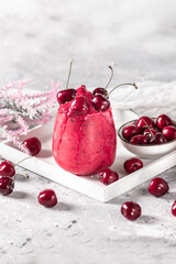 Cherry smoothie with fresh berries on light background