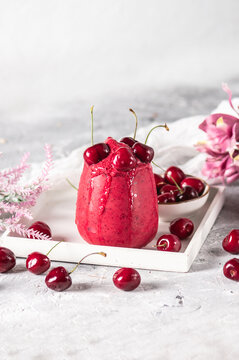 Cherry smoothie with fresh berries on light background