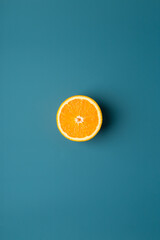 Orange fruit at blue background as minimal picture